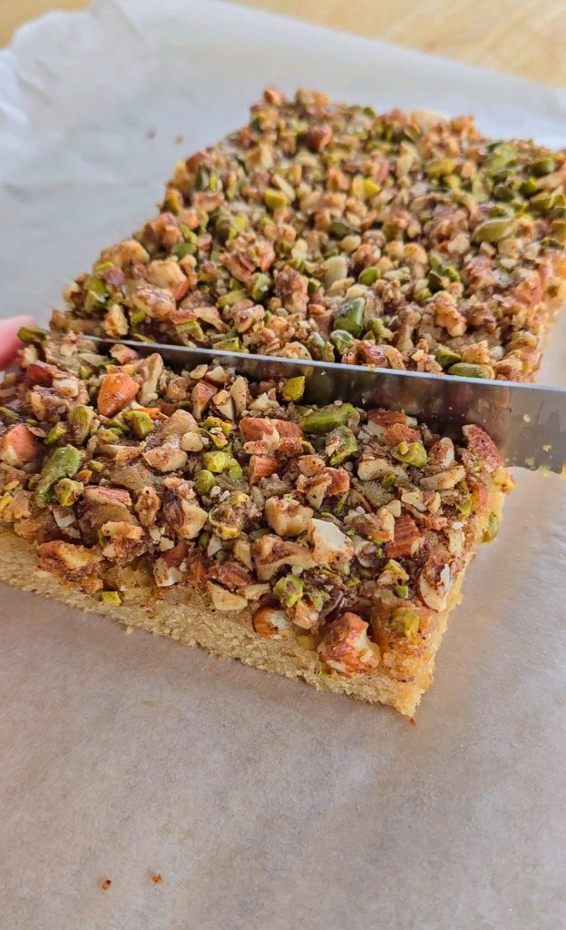 Baklava Blondie right out of the oven, being cut into squares