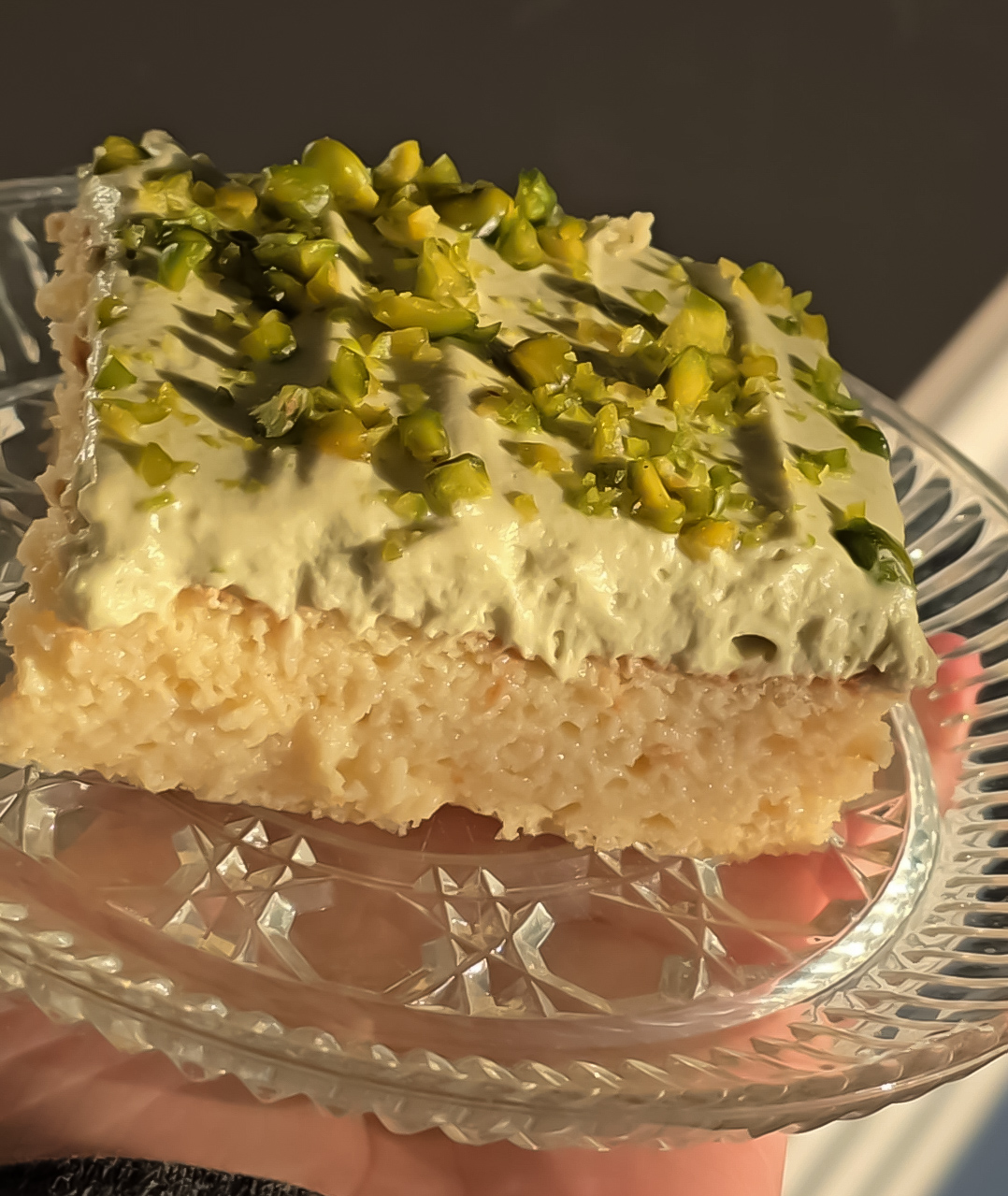Slice of tres leches with a pistachio cream