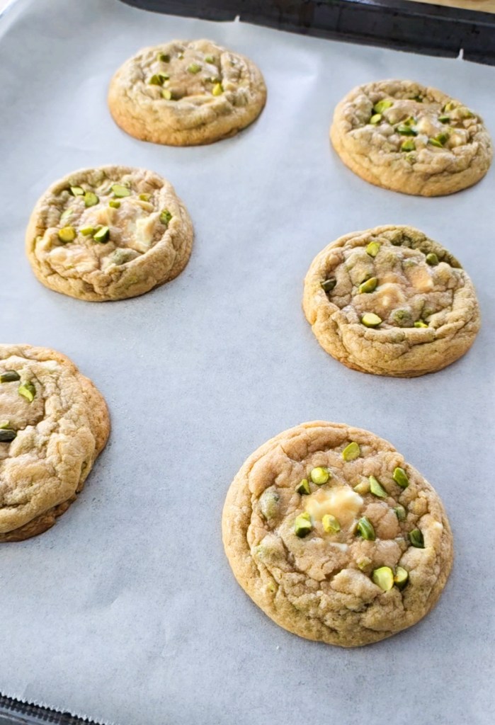 Tray of white chocolate chip pistachio cookies out of the oven