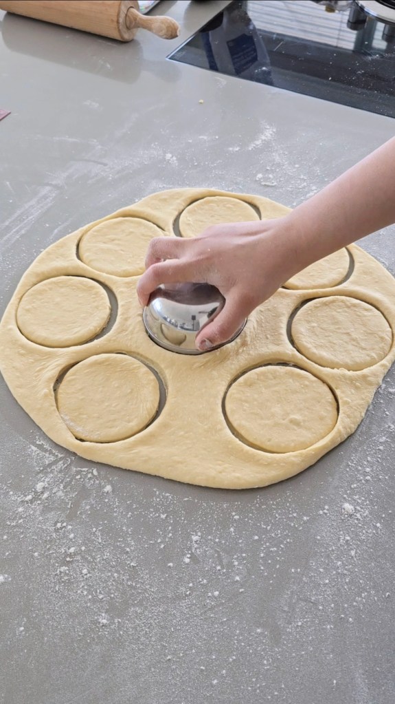 cutting out donut rounds from dough