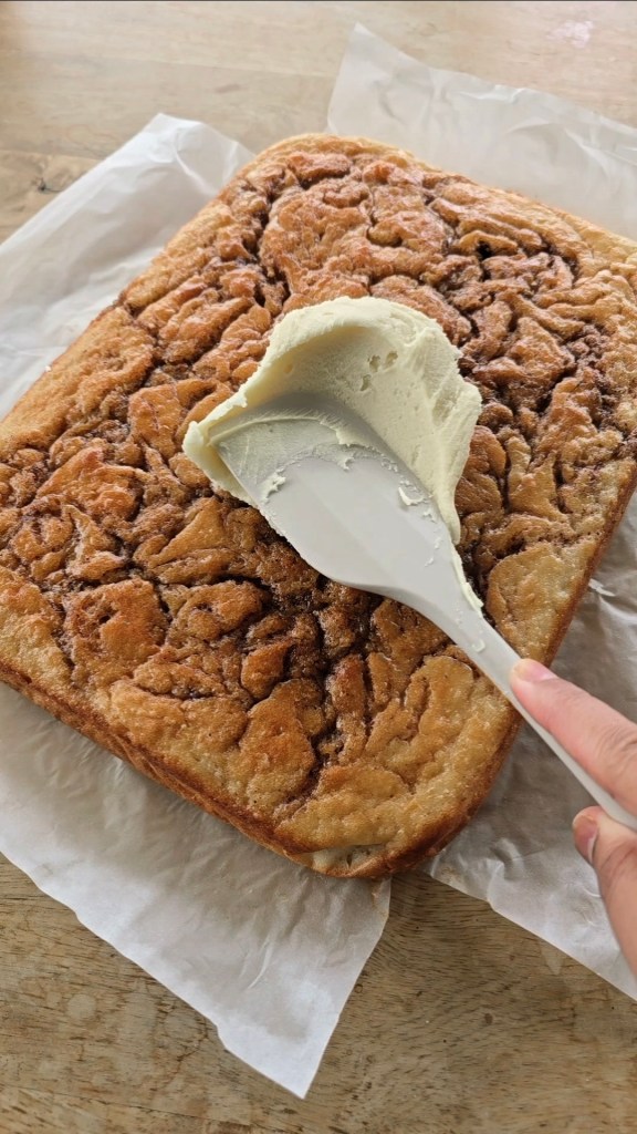 white chocolate ganache spreading on vanilla cinnamon cake