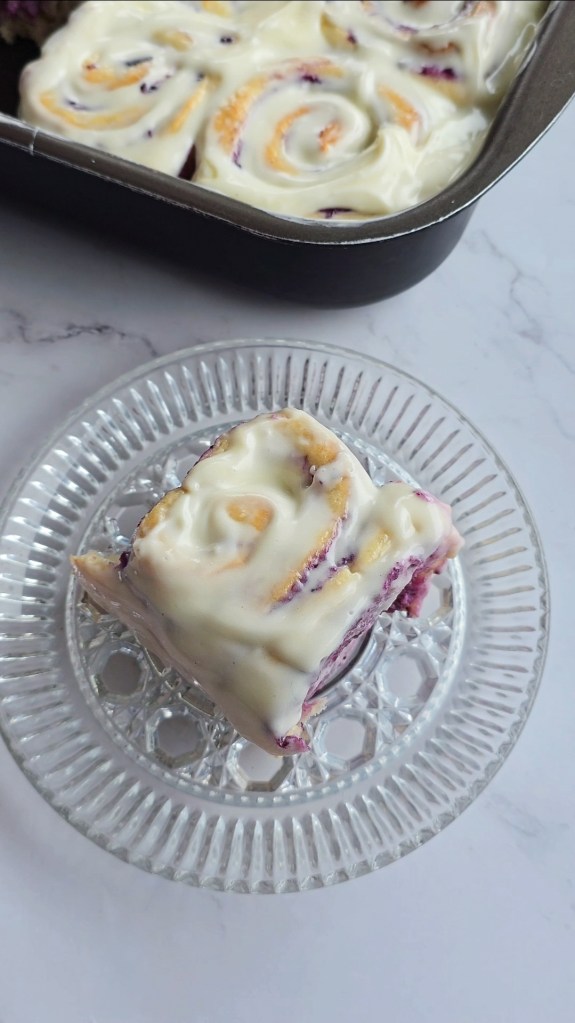 slice of blueberry cheesecake rolls fresh and frosted with cream cheese frosting