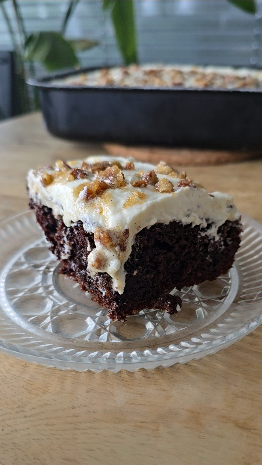 chocolate poke cake slice with whipped cream and pecan crumble